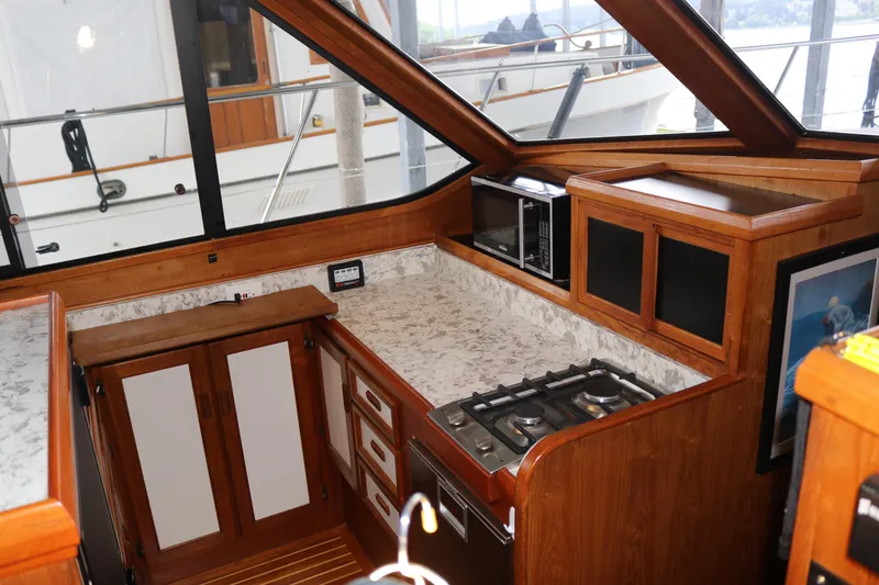 Slide: The Image of Wooden boat kitchen with stove, microwave, and cabinets, featuring a 1990 Cooper Prowler Sedan. - 49