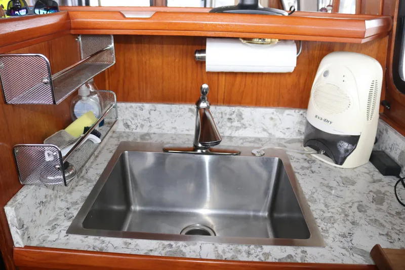 Slide: The Image of Kitchen sink with marble countertop, metal shelves, and dehumidifier in a 1990 Cooper Prowler Sedan. - 51