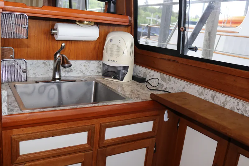 Slide: The Image of 1990 Cooper Prowler Sedan interior kitchen with sink, wooden cabinetry, and countertop appliances. - 52