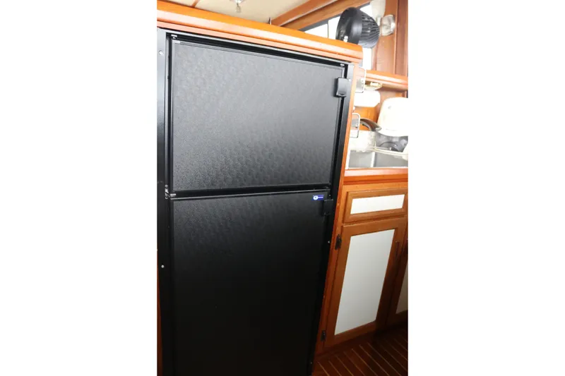 Slide: The Image of Black refrigerator in a wooden kitchen interior of a 1990 Cooper Prowler Sedan. - 57