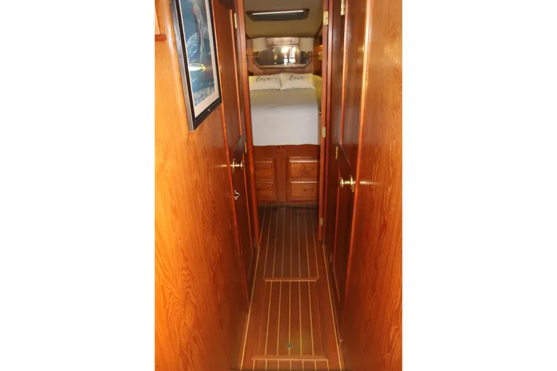 Slide: The Image of Wood-paneled hallway leading to a cozy bedroom with drawers and a framed picture. - 58