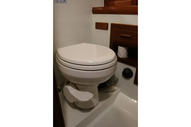 Slide: The Image of Compact bathroom with white toilet and wooden accents in a 1990 Cooper Prowler Sedan. - 71