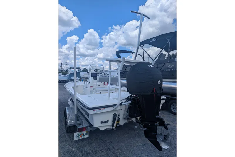 Slide: The Image of 2024 Mako 18 LTS boat with outboard motor, parked under a blue sky. - 3