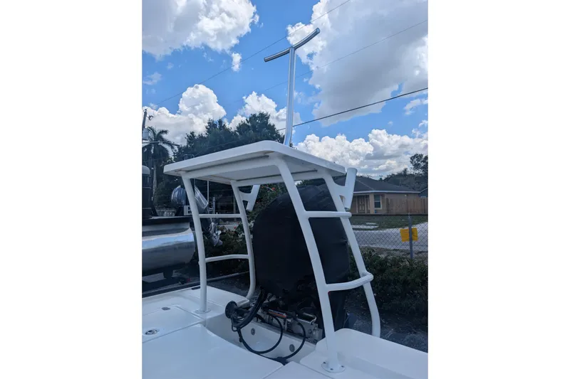 Slide: The Image of 2024 Mako 18 LTS boat with T-top under a partly cloudy sky. - 8