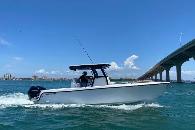 The Image of 2026 Reef Runner 280 boat cruising under a bridge on a sunny day. - 0