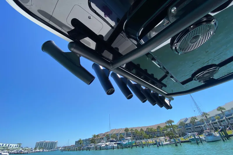 Slide: The Image of 2026 Reef Runner 280 boat with rod holders, docked in a sunny marina. - 11