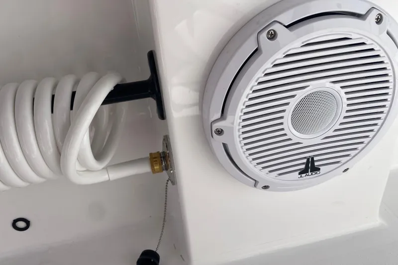 Slide: The Image of White JL Audio speaker and coiled hose on 2026 Reef Runner 280 boat. - 17