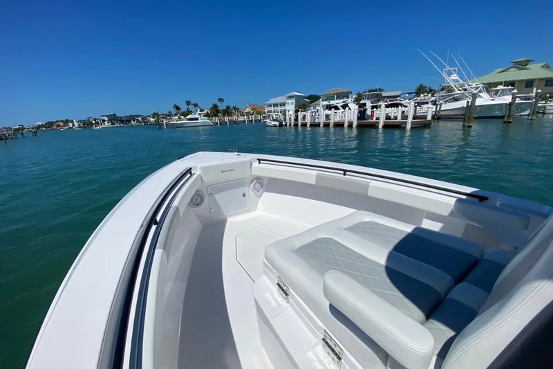 Slide: The Image of 2026 Reef Runner 280 boat docked in a sunny marina with clear blue water. - 19