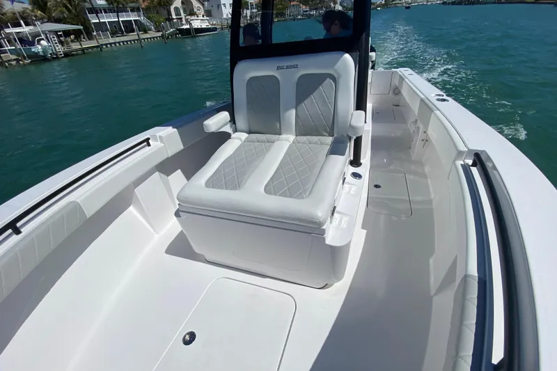 Slide: The Image of 2026 Reef Runner 280 boat interior with cushioned seating on a sunny day. - 20