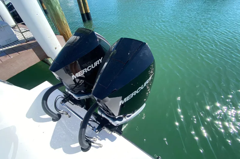 Slide: The Image of Twin Mercury outboard engines on a 2026 Reef Runner 280 boat docked by the water. - 3