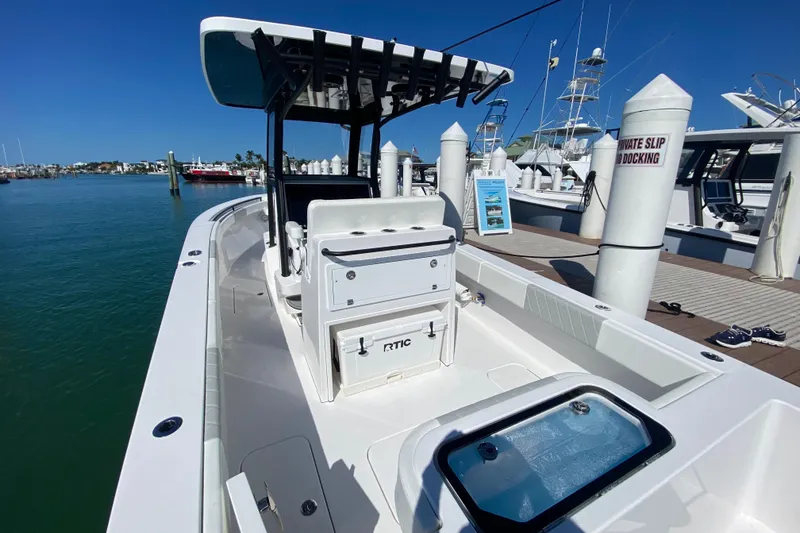 Slide: The Image of 2026 Reef Runner 280 boat docked at marina under clear blue sky. - 5