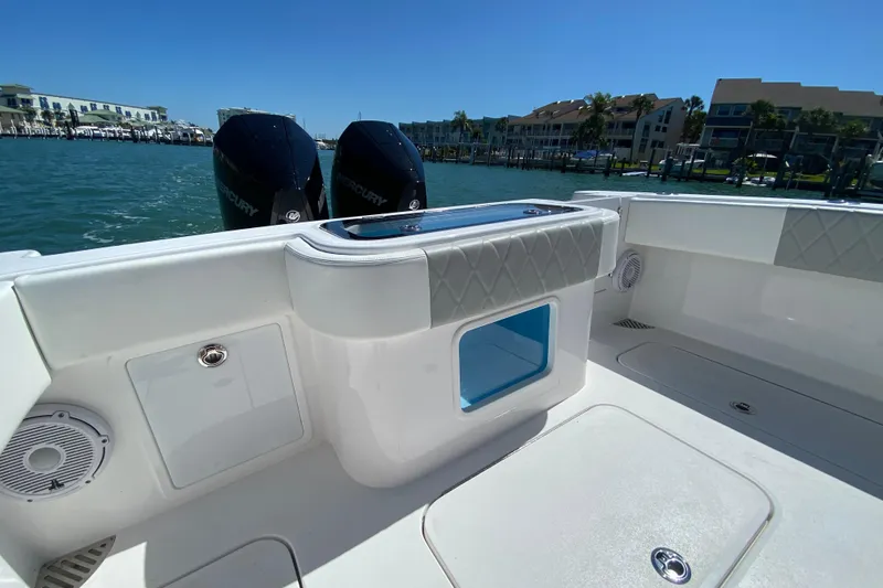 Slide: The Image of 2026 Reef Runner 280 boat interior with dual Mercury engines, docked by waterfront buildings. - 6