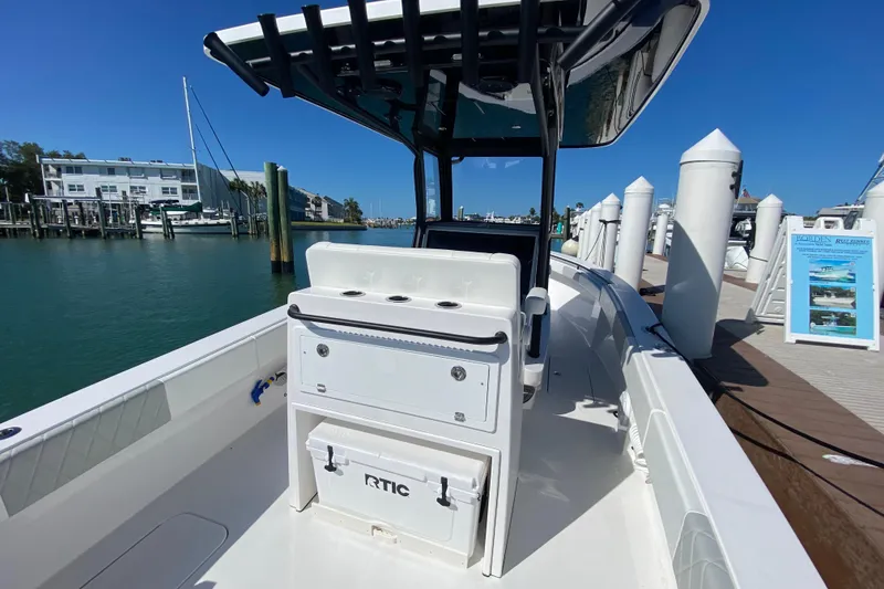 Slide: The Image of 2026 Reef Runner 280 boat docked at marina under clear blue sky. - 7