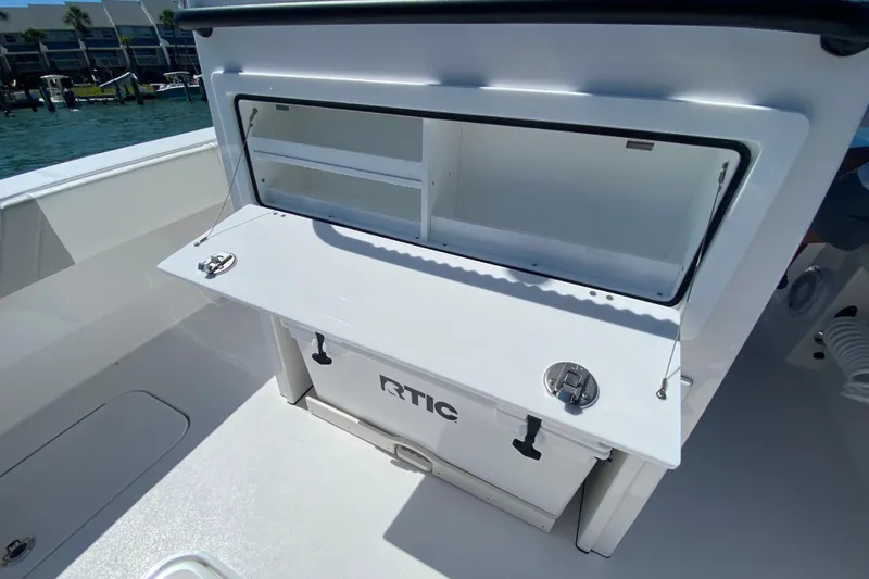 Slide: The Image of 2026 Reef Runner 280 boat with open storage compartment and RTIC cooler on deck. - 9