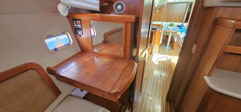 Slide: The Image of Interior of 2007 Hunter 45 Center Cockpit yacht with wooden desk and seating area. - 12