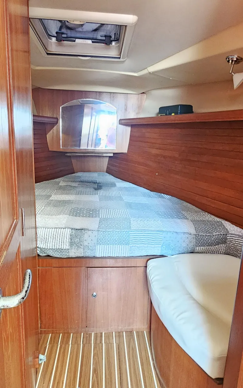 Slide: The Image of 2007 Hunter 45 Center Cockpit interior cabin with wood paneling and cozy bed. - 15
