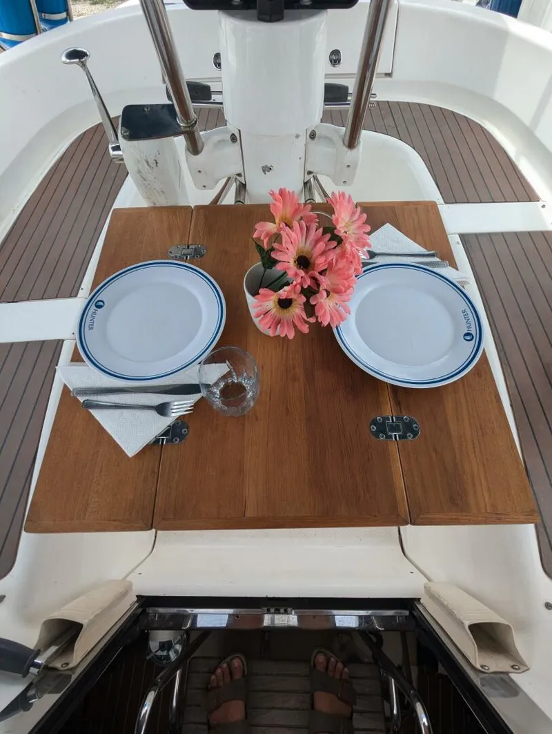 Slide: The Image of Dining setup on 2007 Hunter 45 Center Cockpit yacht with flowers and plates. - 21