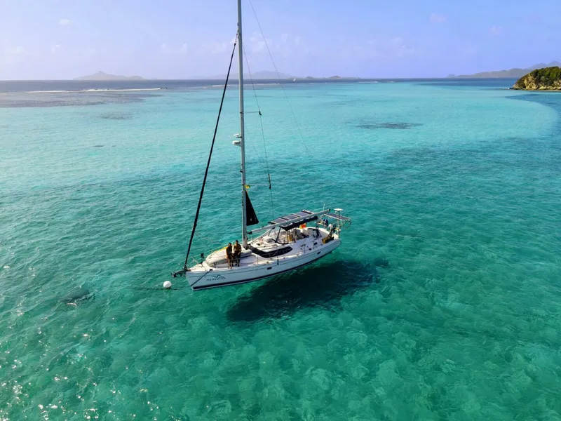Slide: The Image of Sailboat "Hunter 45 Center Cockpit" 2007 on turquoise sea, clear skies, distant islands. - 31