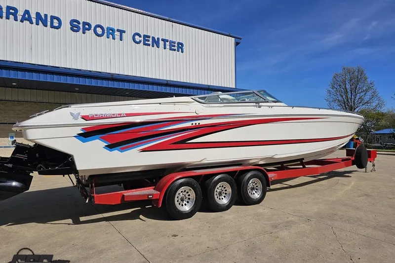 Slide: The Image of 2001 Formula 382 FASTech boat on red trailer outside Grand Sport Center. - 11