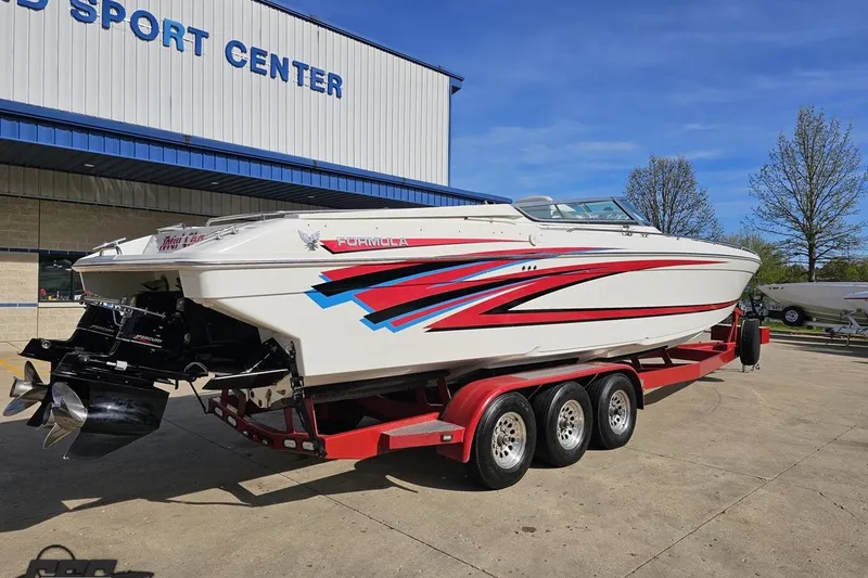 Slide: The Image of 2001 Formula 382 FASTech boat on a red trailer outside a sport center. - 17