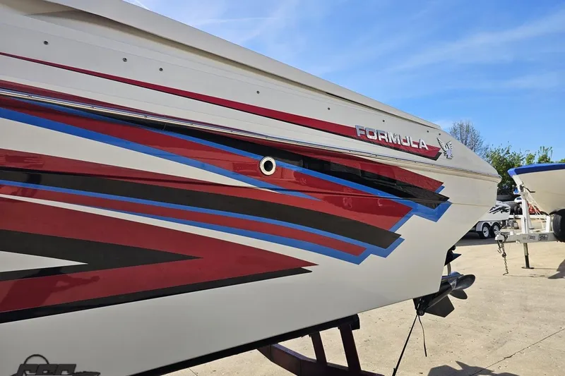 Slide: The Image of 2001 Formula 382 FASTech boat with vibrant red, blue, and black graphics on the hull. - 24