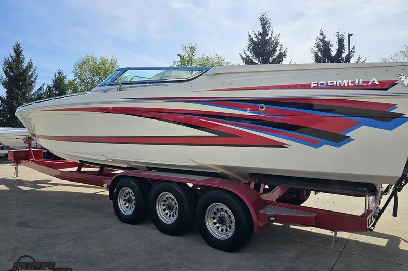 Slide: The Image of 2001 Formula 382 FASTech boat on trailer with vibrant red and blue graphics. - 27