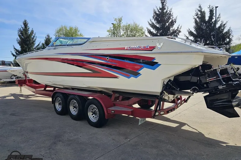 Slide: The Image of 2001 Formula 382 FASTech boat on a red trailer, featuring vibrant graphics. - 28