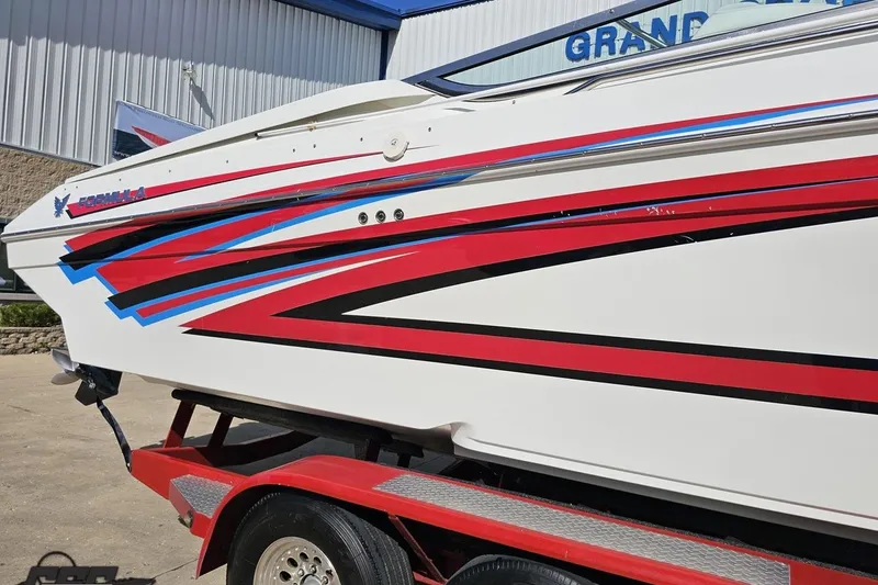 Slide: The Image of 2001 Formula 382 FASTech boat with vibrant red and blue graphics on a trailer. - 7