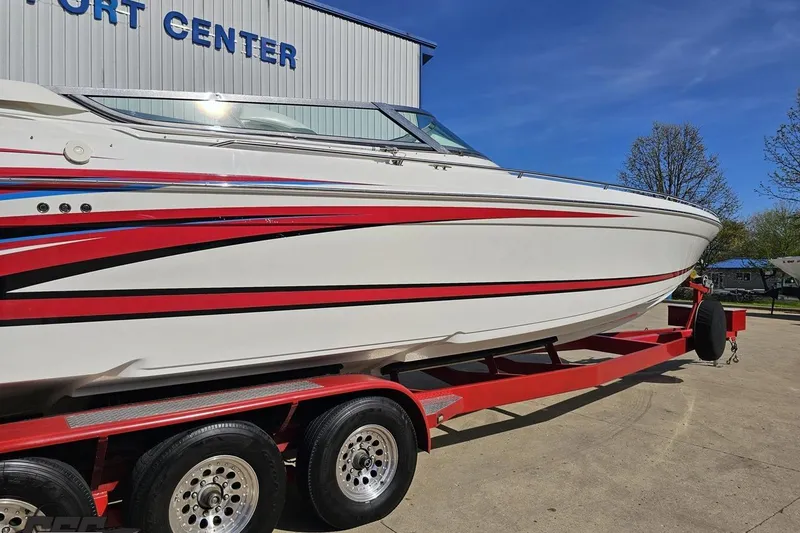 Slide: The Image of 2001 Formula 382 FASTech boat on red trailer, parked near a building. - 9