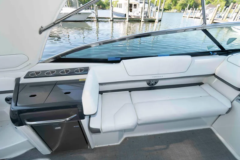 Slide: The Image of 2016 Formula 310 Bowrider docked at marina, featuring spacious seating and sleek design. - 11