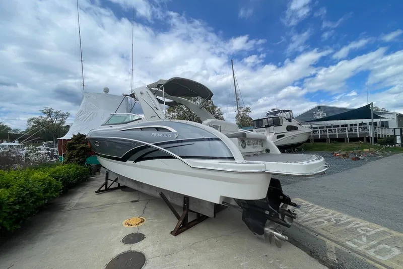 Slide: The Image of 2016 Formula 310 Bowrider boat on display at a marina under a cloudy sky. - 3