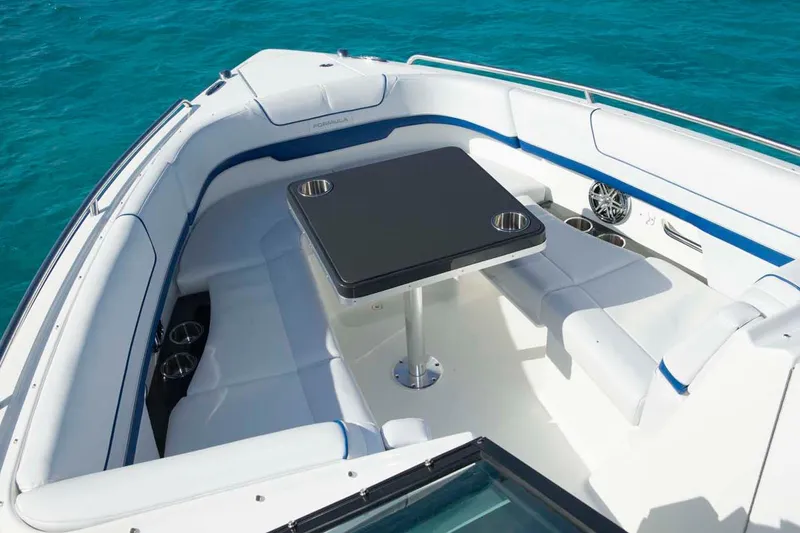 Slide: The Image of Manufacturer Provided Image: 2016 Formula 310 Bowrider boat interior with seating and table on turquoise water. - 5
