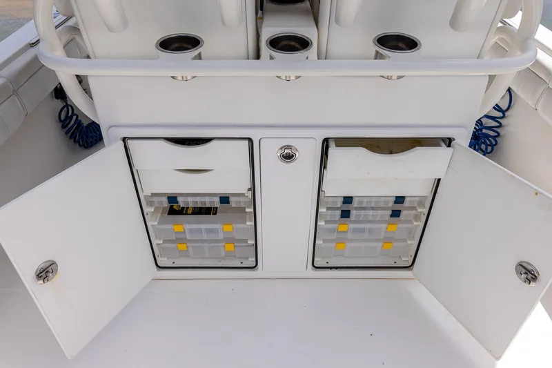 Slide: The Image of 2018 Regulator 28 boat storage compartments with organized tackle boxes and drawers. - 10