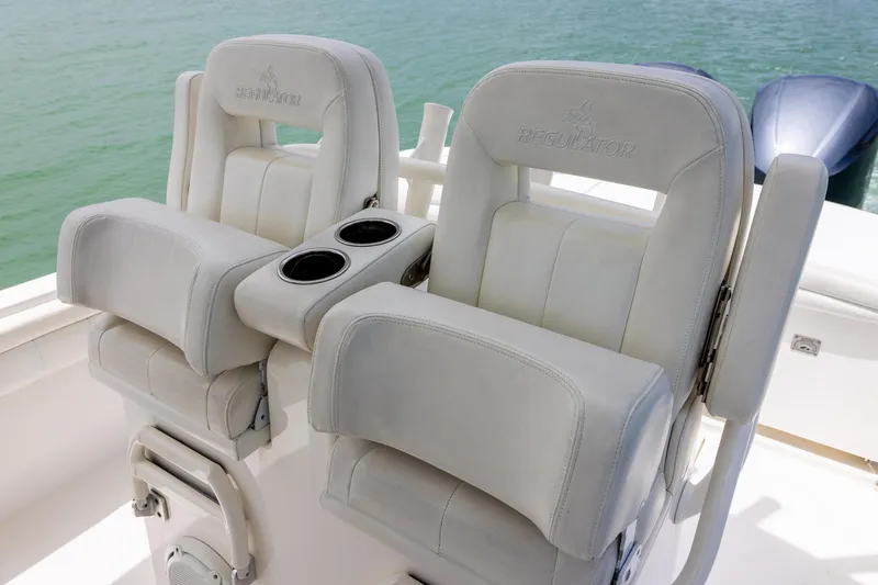 Slide: The Image of 2018 Regulator 28 boat seats with cup holders, set against a serene water backdrop. - 13