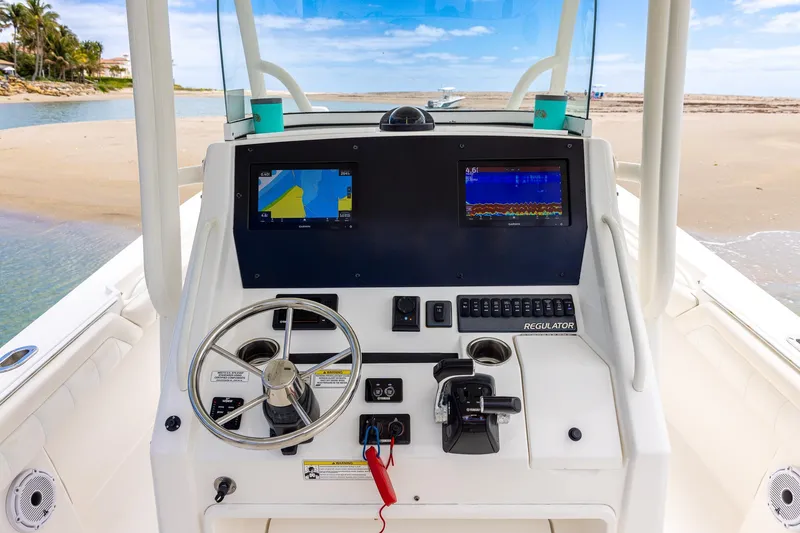 Slide: The Image of 2018 Regulator 28 boat dashboard with navigation screens and steering wheel. - 19