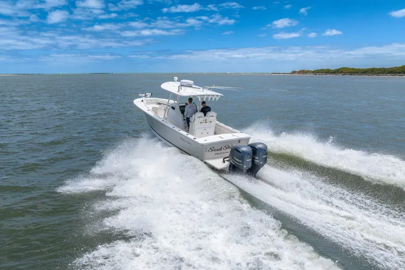 Slide: The Image of 2018 Regulator 28 boat cruising on open water under a clear blue sky. - 2