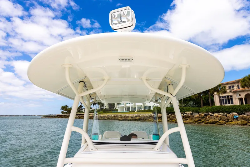 Slide: The Image of 2018 Regulator 28 boat with T-top, cruising near waterfront homes. - 22
