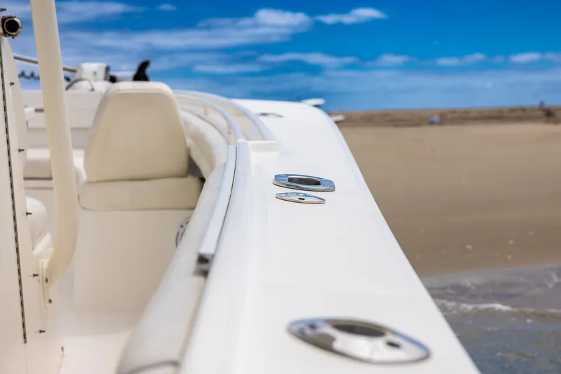 Slide: The Image of 2018 Regulator 28 boat docked on sandy beach under clear blue sky. - 24
