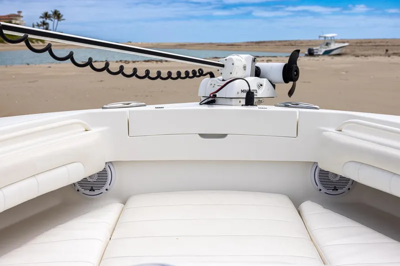 Slide: The Image of 2018 Regulator 28 boat interior with white seating and trolling motor, beach in background. - 29