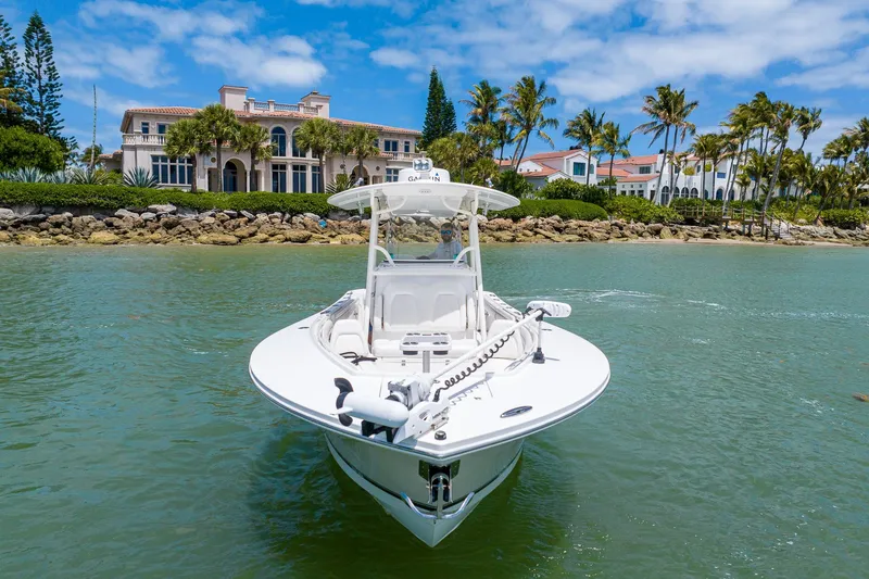 Slide: The Image of 2018 Regulator 28 boat on water near luxury waterfront homes and palm trees. - 3