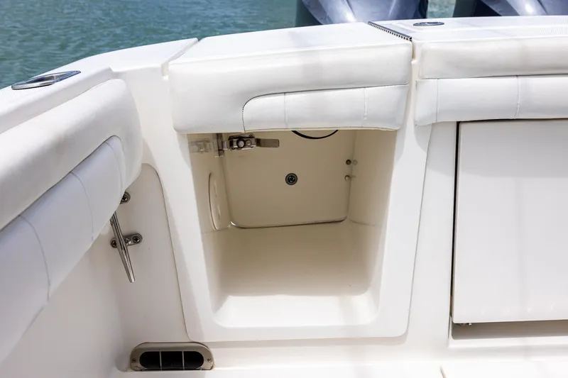 Slide: The Image of 2018 Regulator 28 boat interior storage compartment with white cushioned seating. - 7