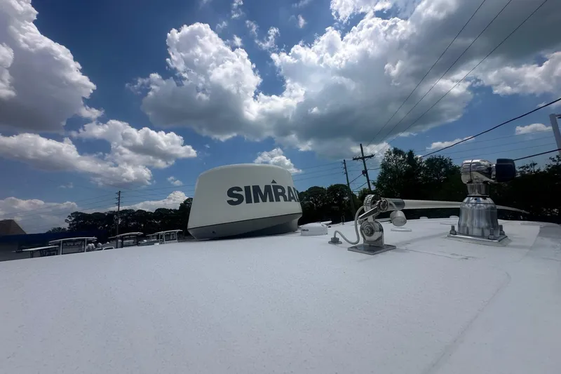 Slide: The Image of 2019 Sea Hunt Gamefish 27 Coffin Box boat with Simrad radar under a cloudy sky. - 11