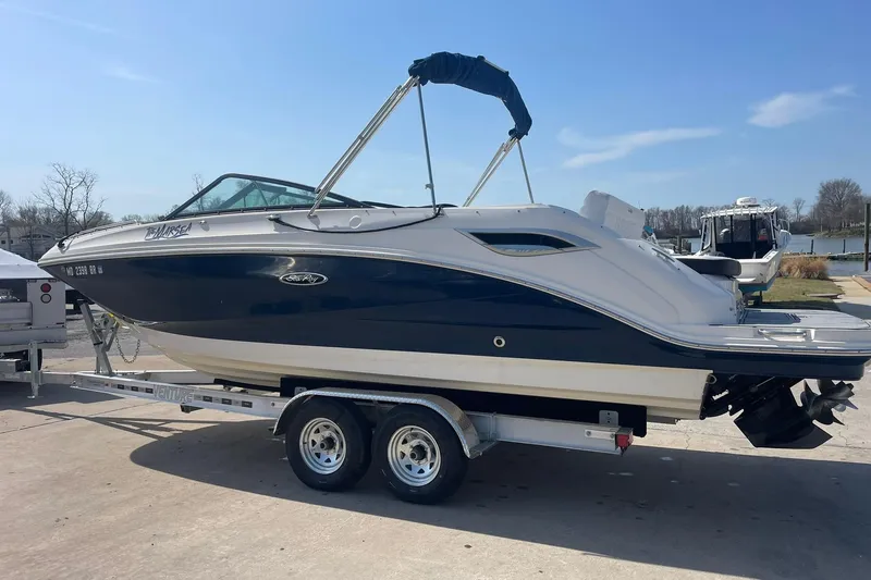 The Image of 2019 Sea Ray SDX 250 boat on trailer, parked near a waterfront. - 0