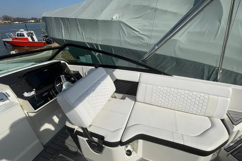 Slide: The Image of 2019 Sea Ray SDX 250 boat interior with white seating and steering console. - 11
