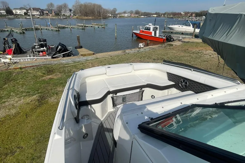 Slide: The Image of 2019 Sea Ray SDX 250 boat docked by a scenic waterfront with other boats. - 21