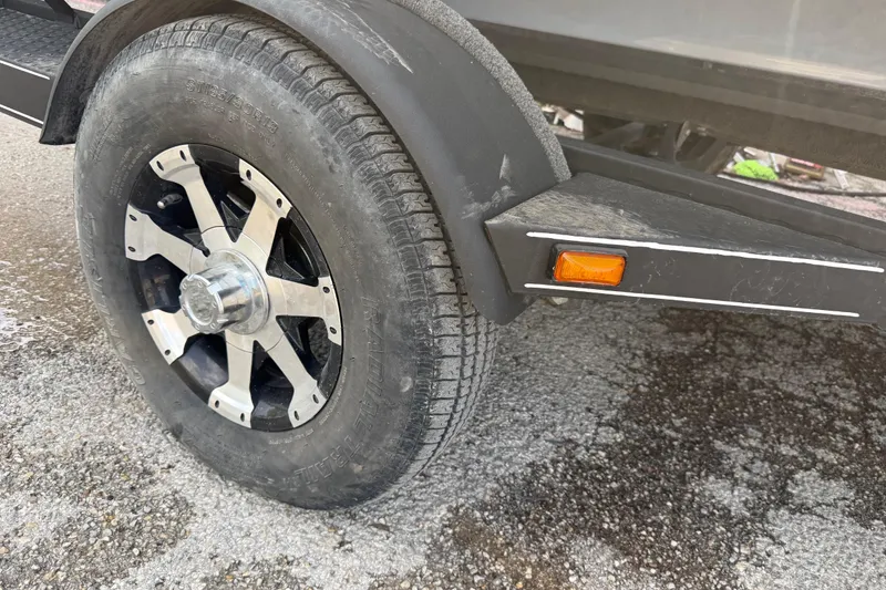 Slide: The Image of 2016 Stratos 176 VLO trailer wheel with black and silver rim on asphalt. - 28