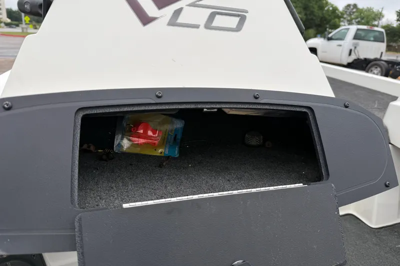 Slide: The Image of Open storage compartment on 2016 Stratos 176 VLO boat, featuring rod holders and carpeted deck. - 44