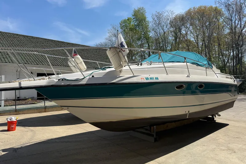 The Image of Chaparral Signature 310 boat, 1995 model, docked outdoors with teal accents and canopy. - 0