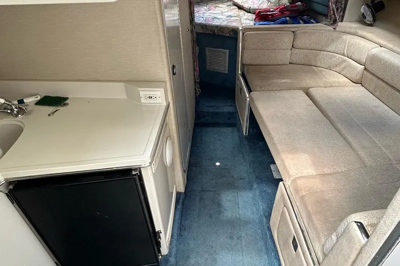 Slide: The Image of 1995 Chaparral Signature 310 yacht interior with sofa and kitchenette. - 16