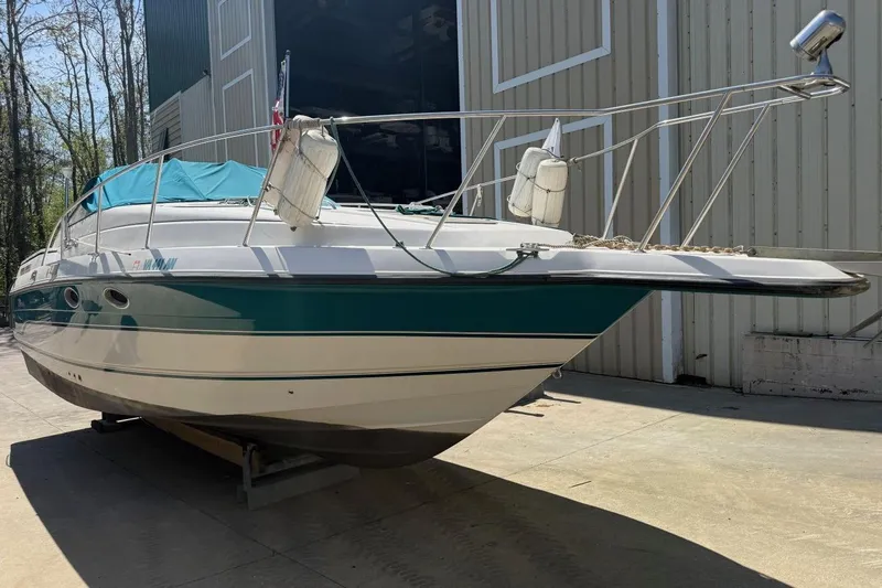 Slide: The Image of 1995 Chaparral Signature 310 boat docked outdoors, featuring teal and white design. - 2